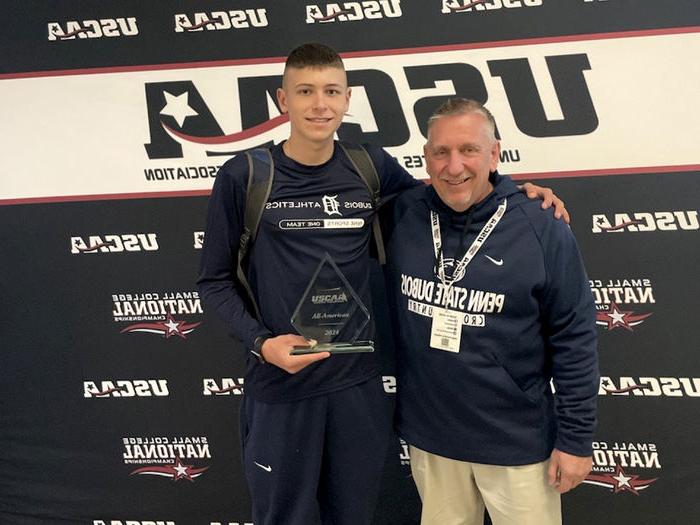 Penn State DuBois cross-country athlete Jack Craig, right, joins head coach Scott Creighton for a photo with his award for finishing sixth national at the USCAA National Championships.